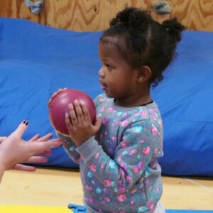 girl playing with a ball during her physical therapy session at sensory solutions 