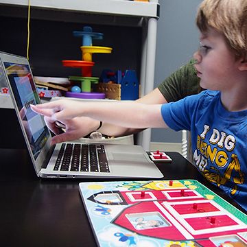 child working with Augmentative and Alternative Communication (AAC) devices during pediatric therapy services at Sensory Solutions